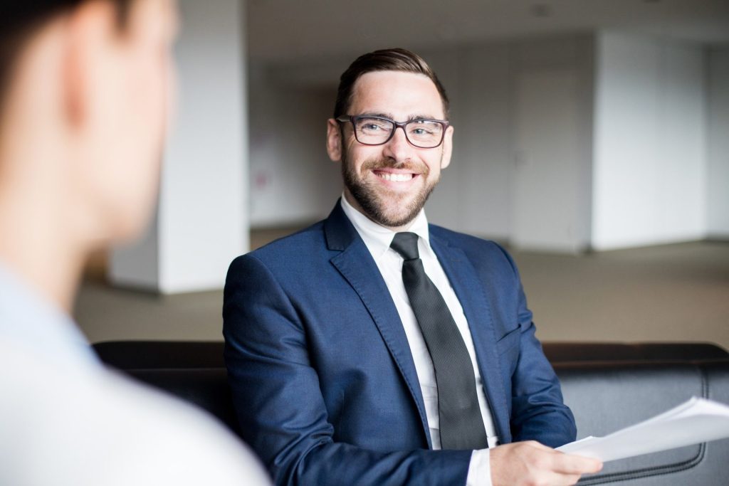 Smiling man sitting and looking at person